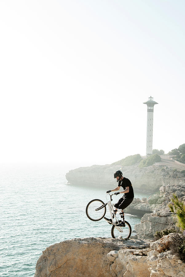 Nature Photograph - Mountain Biker Doing Trick On Seashore by Daniel Santacatalina