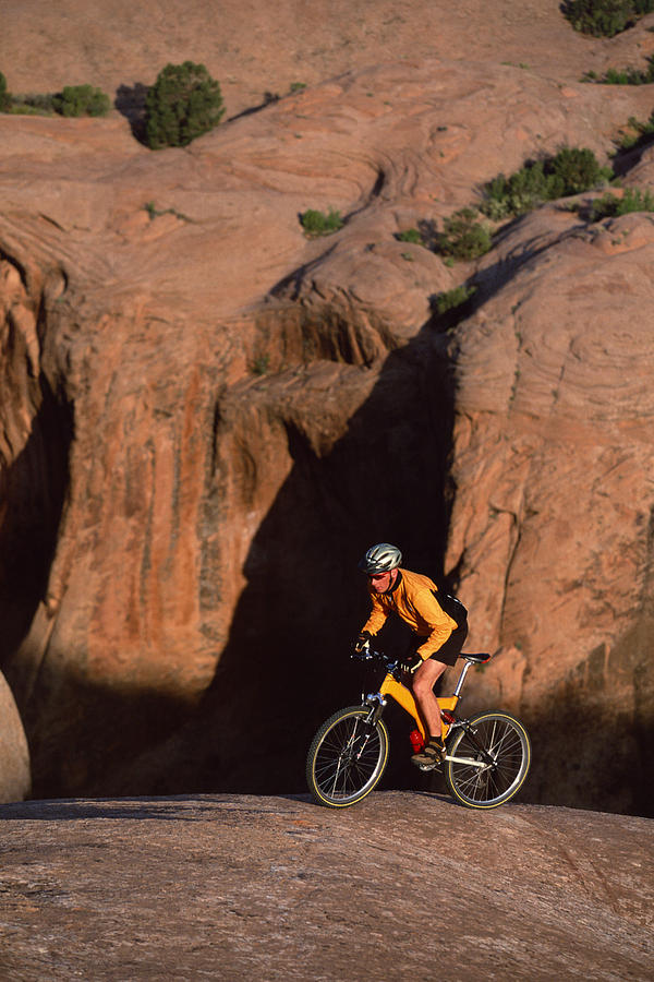 Mountain biker on Slickrock Trail at Moab , UT Photograph by Comstock