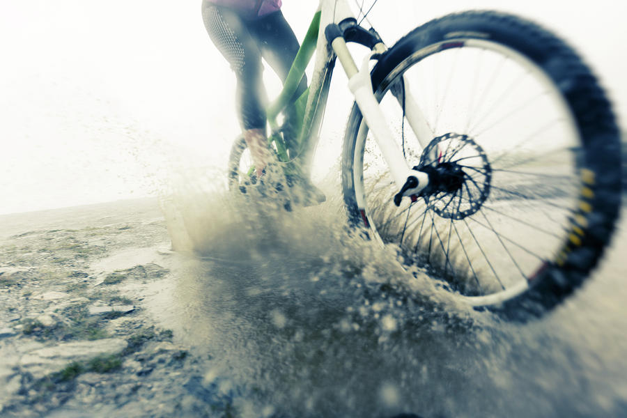 Mountain Biker Racing Through Puddle Photograph by Nullplus