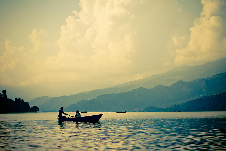 Mountain lake with boat Photograph by Raimond Klavins