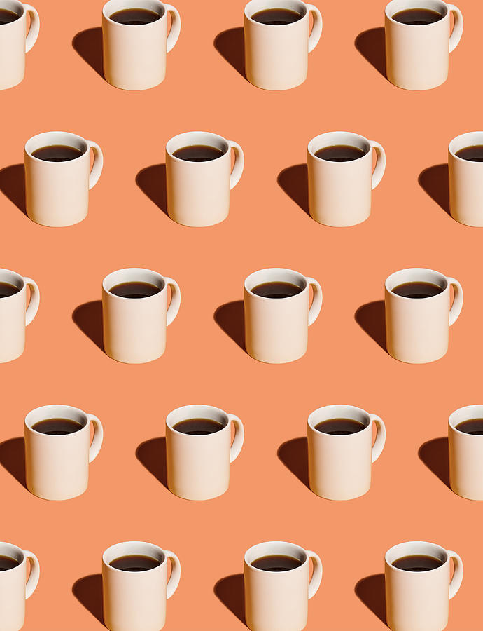 Mugs of black coffee in rows against peach background Photograph by Mara Ohlsson