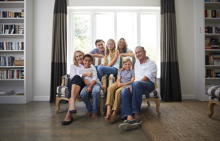 Multi-ethnic family smiling in house Photograph by Portra Images