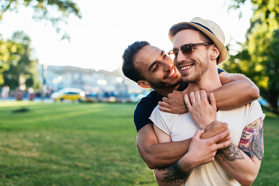 Multi ethnic gay couple hugging Photograph by Drazen_