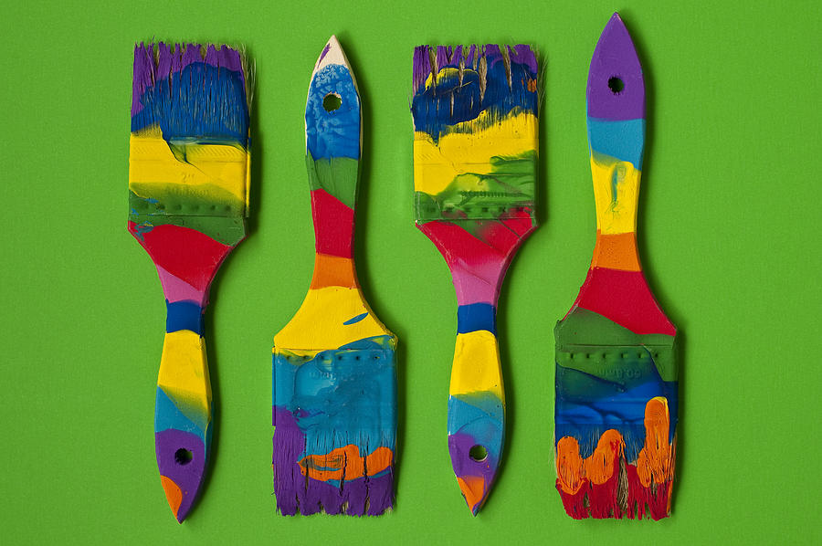 Multicolored paint brushes on green background Photograph by Jim Corwin