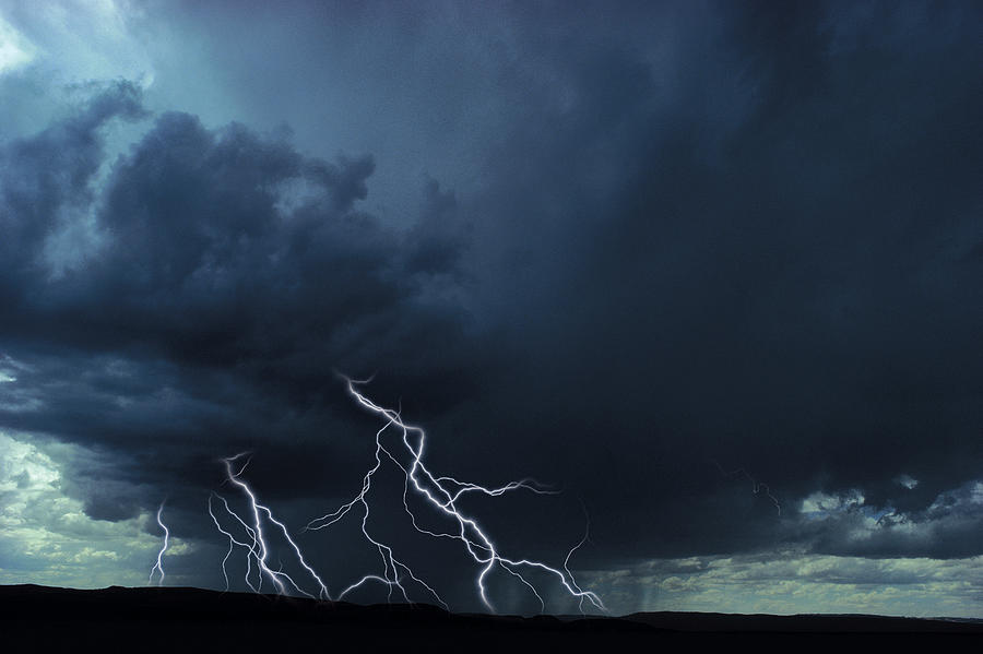 Multiple lightning bolts over rural landscape Photograph by Comstock