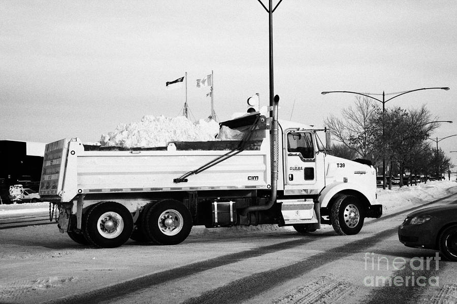 Winter Photograph - municipal city dump truck taking away snow cleared from parking lots and roads in Saskatoon Saskatch by Joe Fox
