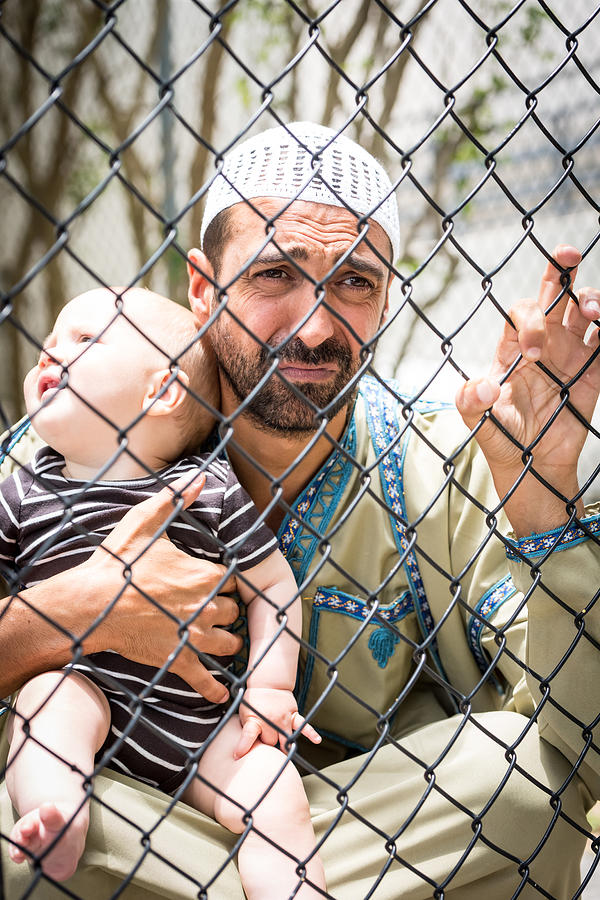 Muslim refugee holding his baby Photograph by Juanmonino