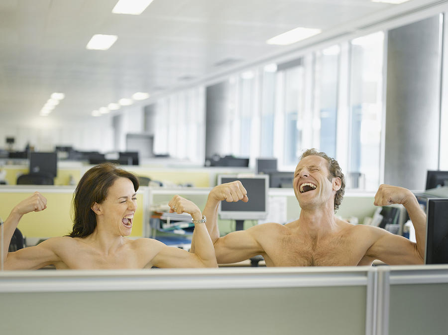 Naked businesspeople flexing muscles in office Photograph by Robert Daly