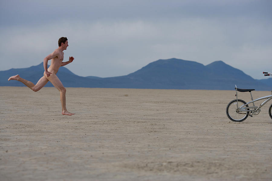 Naked Man Running After His Bicycle Photograph by Woods Wheatcroft.