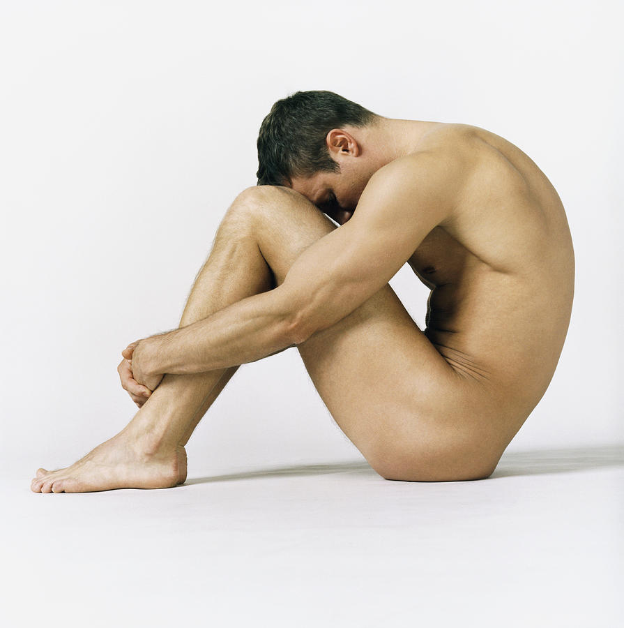 Naked Man Sitting With His Hands Around His Knees Photograph by Digital Vision.