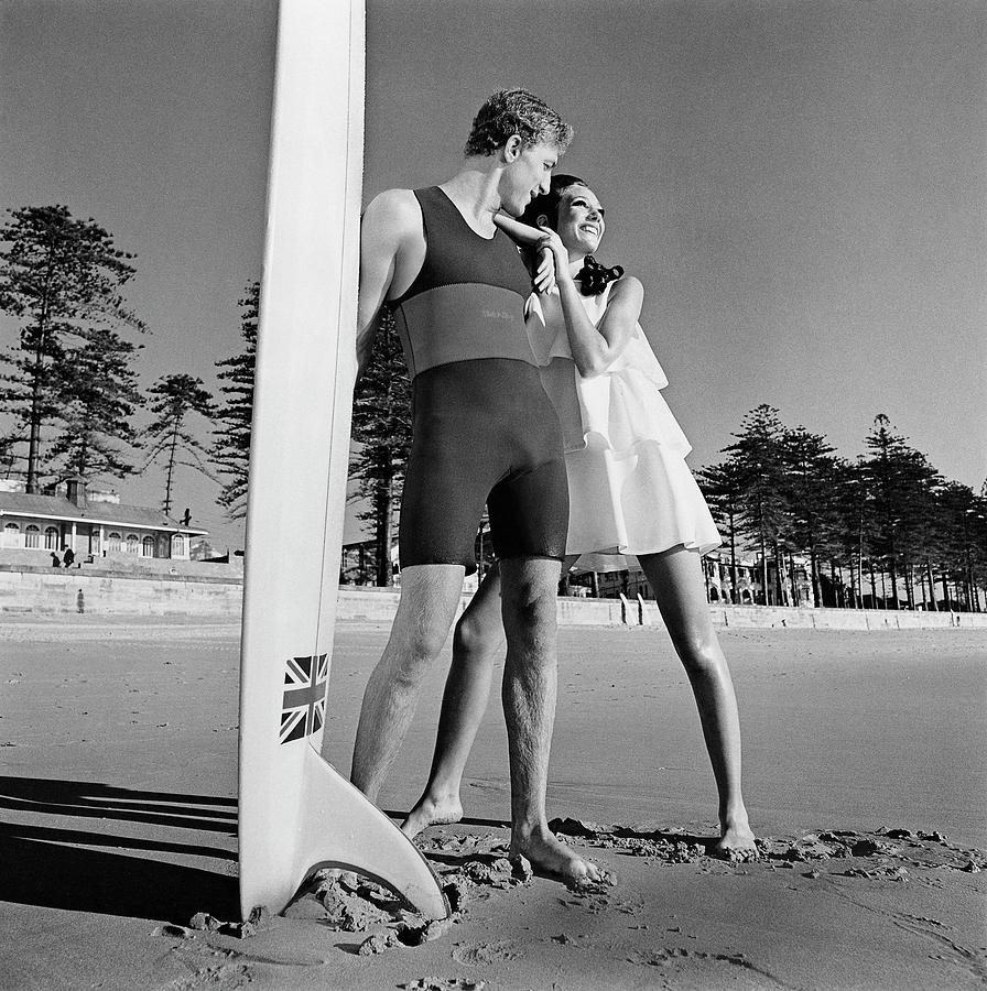 Nat Young And Marisa Berenson By A Surfboard Photograph by Arnaud de Rosnay