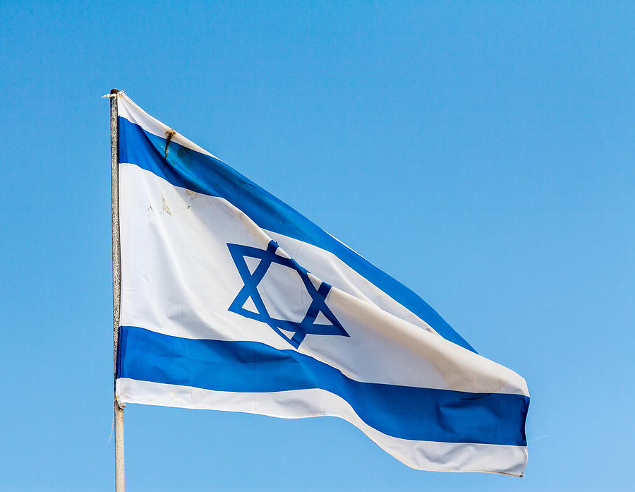 National Flag of Israel against blue sky Photograph by Kolderal