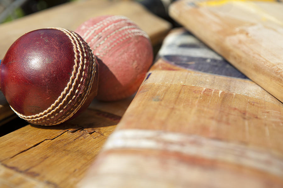 New and old cricket ball lying on bats Photograph by OrangeDukeProductions