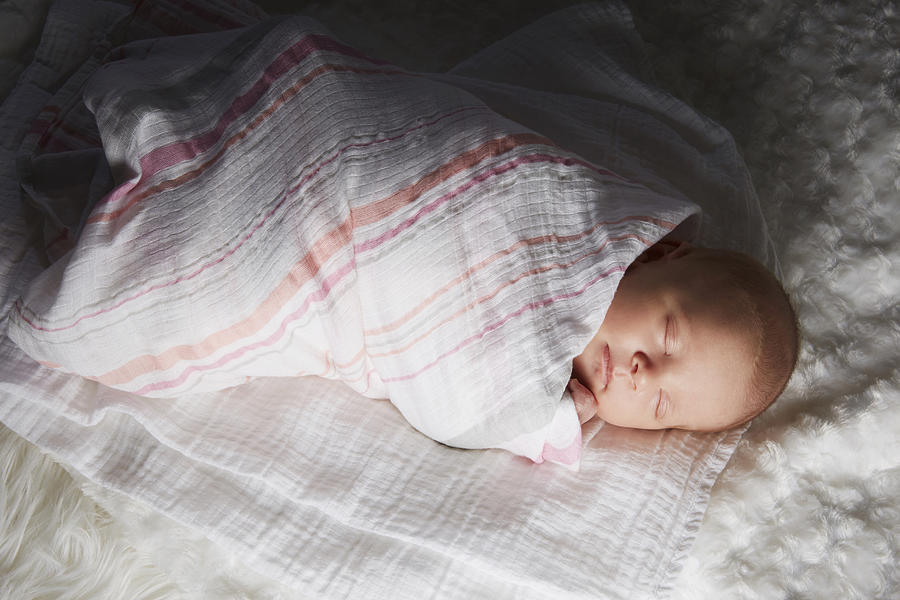 Newborn baby swaddled in blanket Photograph by Jasper Cole