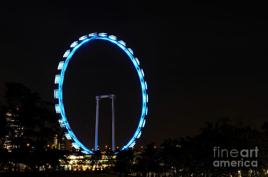 Night shot of the Singapore Flyer ferris wheel at Marina Bay Photograph by Imran Ahmed