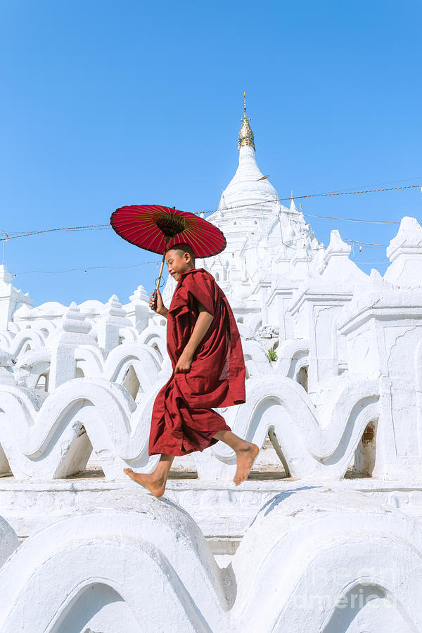 Novice monk jumping on white pagoda - Mandalay - Burma Photograph by Matteo Colombo