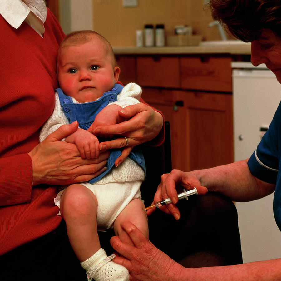 nurse-administering-vaccine-into-leg-of-young-baby-photograph-by-saturn