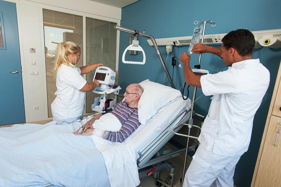 Nurses Working With Senior Man Photograph by Arno Massee/science Photo ...