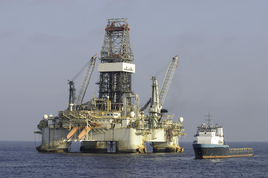 Ocean oil rig with supply boat Photograph by Bradford Martin
