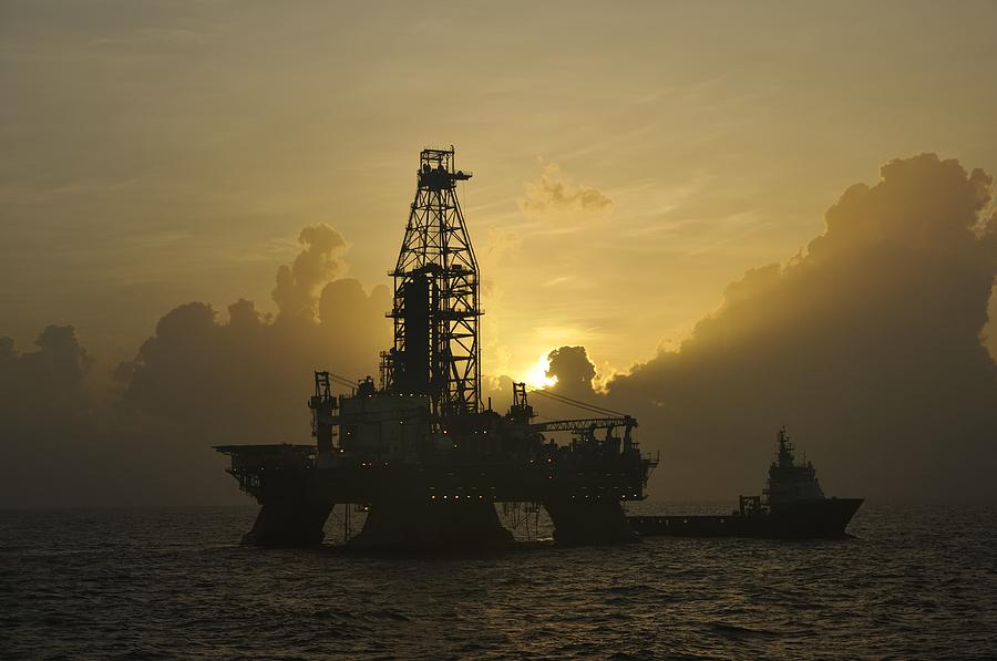 Offshore Oil Rig With Sun And Clouds Photograph by Bradford Martin