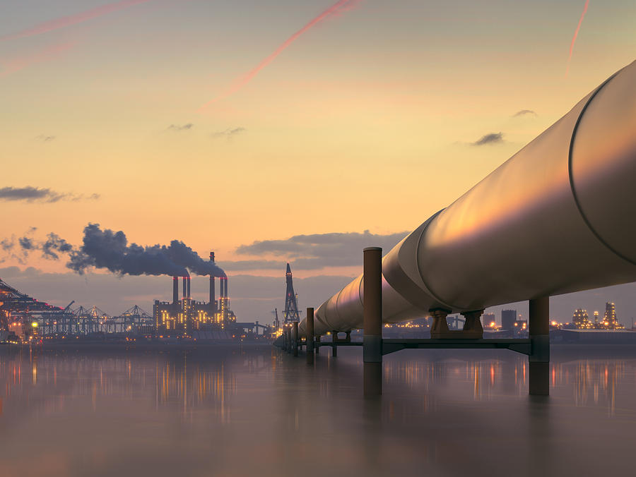 Oil pipeline in industrial district with factories at dusk Photograph by Spooh