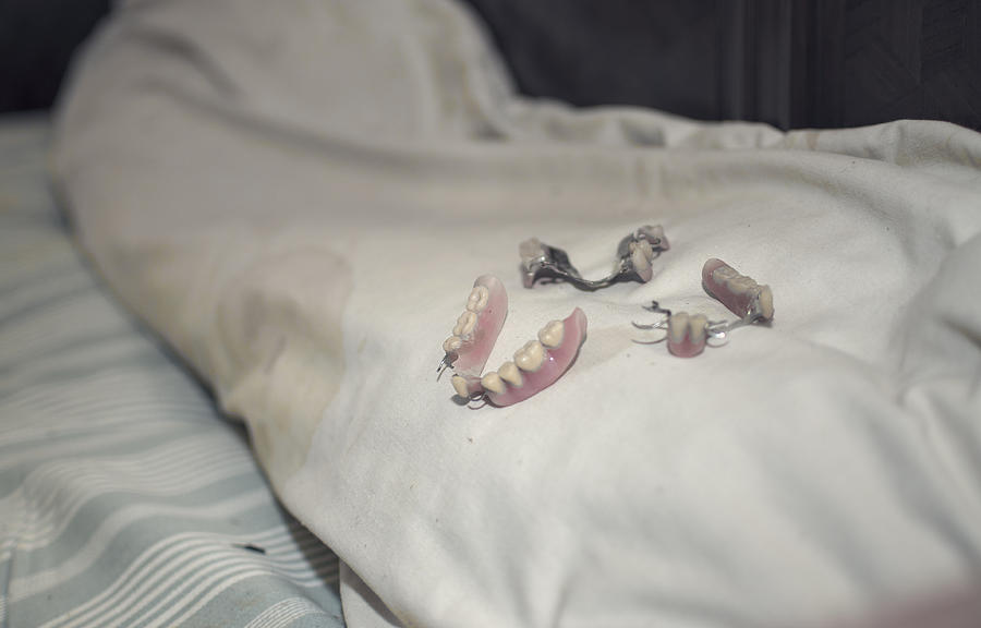 Old dentures on top of a pillow Photograph by Rui Almeida Fotografia