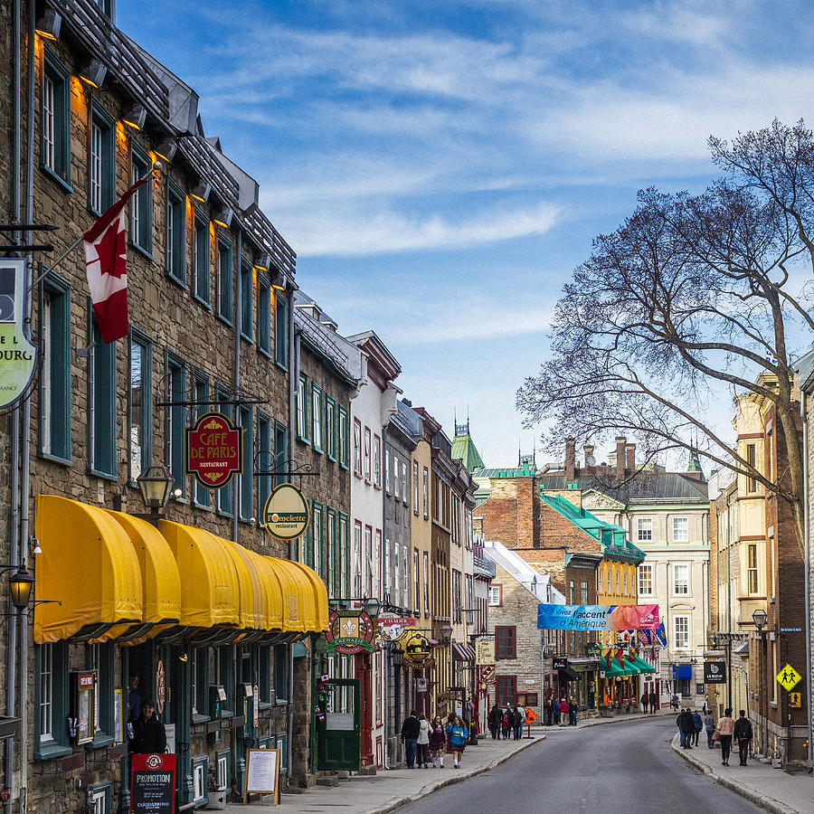 Old Quebec city street scene, where historical buildings and people are visible in the image. Photograph by Instants