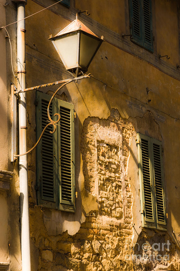 Old street lamp and shuttered windows in Montalcino Photograph by Peter Noyce