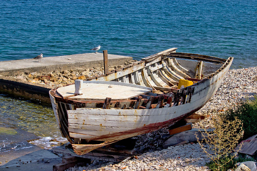 Old wooden boat broken by the sea Photograph by Brch Photography