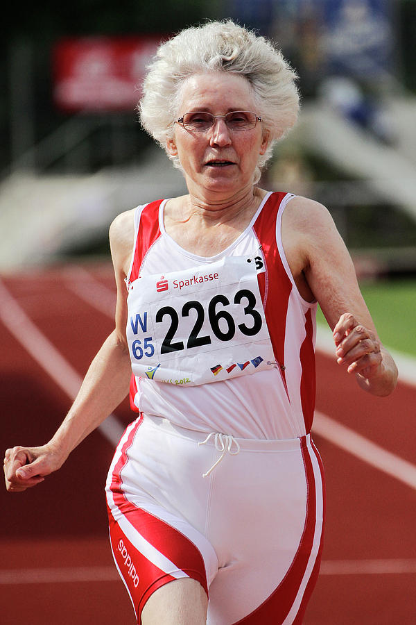 Older Female Athlete Runs To Camera Photograph by Alex Rotas