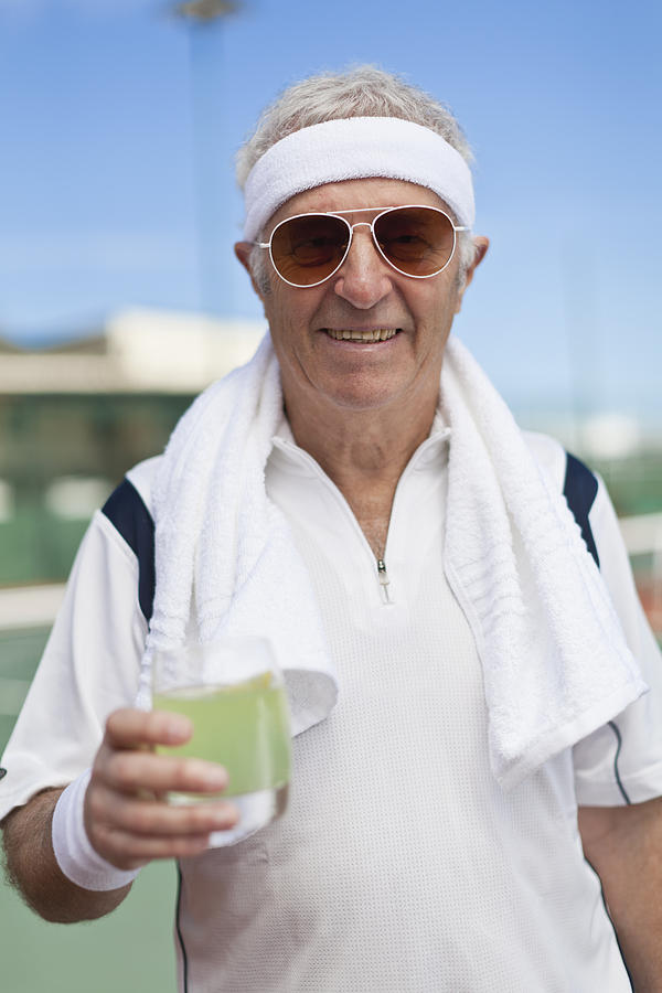 Older man drinking lemonade outdoors Photograph by Hybrid Images