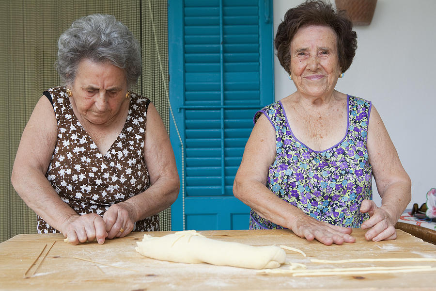 Older women making pasta together Photograph by Judith Haeusler