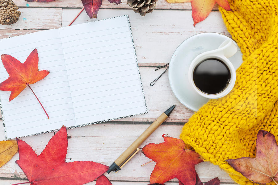 Open notebook, pen and cup of coffee, framed with autumn leaves on white background. Flat lay. Top view. Empty copy space for text Photograph by Carol Yepes