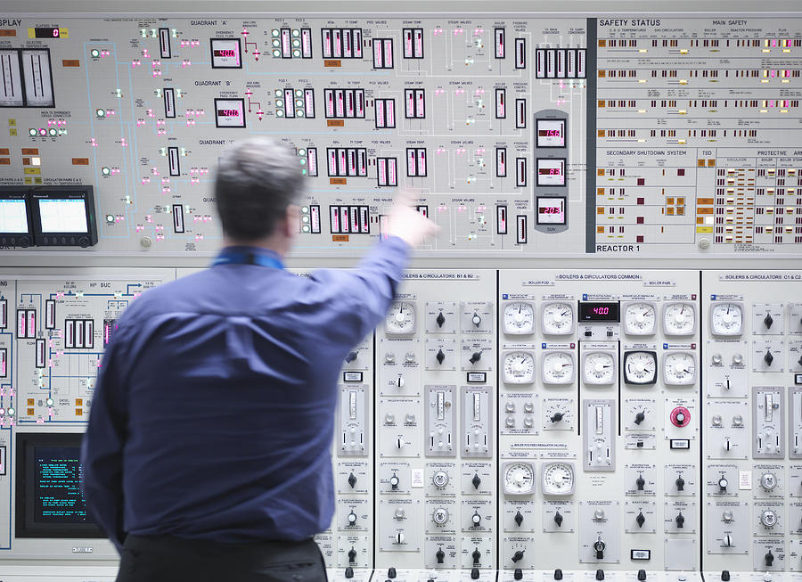 Operator adjusting controls in nuclear power station control room simulator Photograph by Monty Rakusen