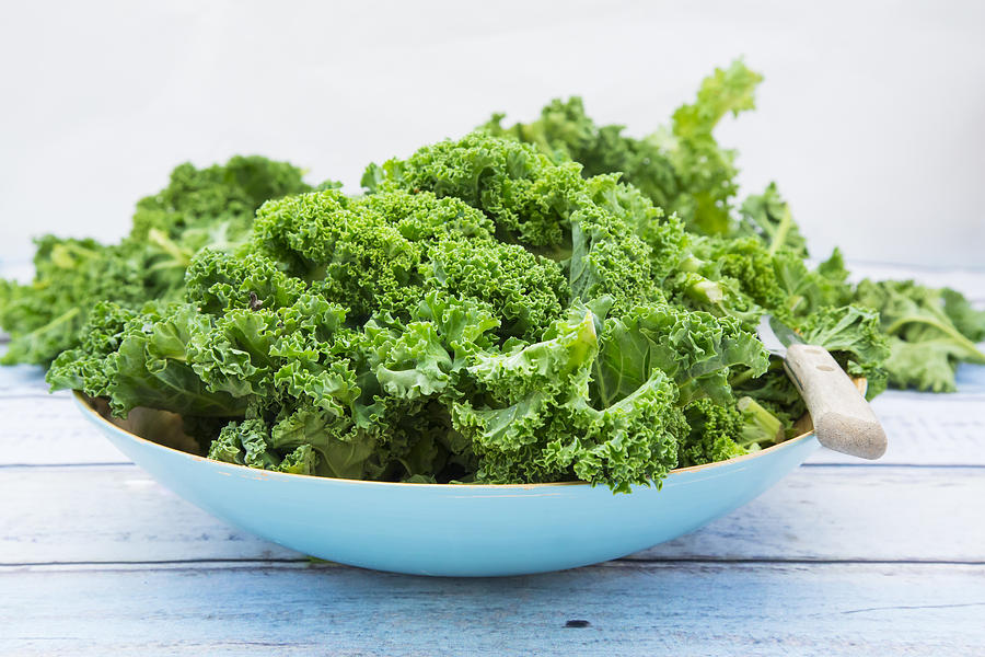 Organic kale in a blue bowl on wood Photograph by Larissa Veronesi