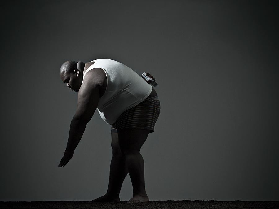 Overweight man bending over Photograph by Image Source