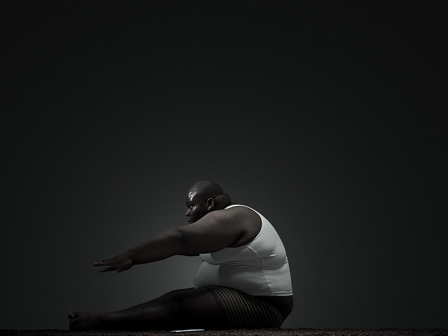 Overweight man doing sit up Photograph by Image Source