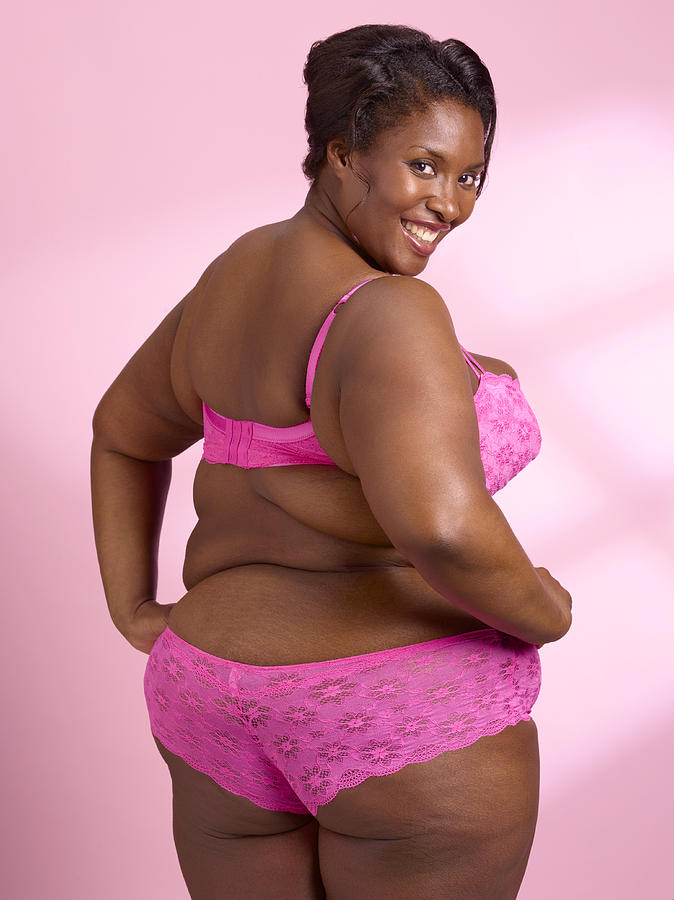 Overweight woman on pink background Photograph by Peter Dazeley