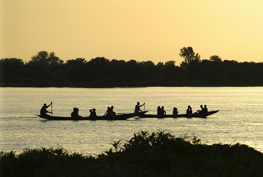 Paddling on the Niger River at sunset Photograph by Shanna Baker