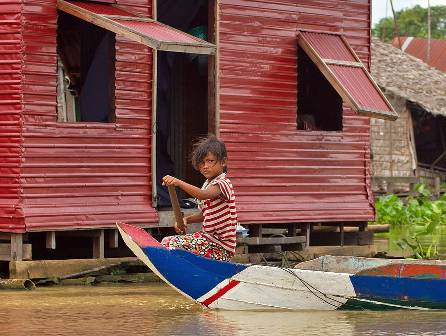 Paddling through the village Photograph by David Freuthal