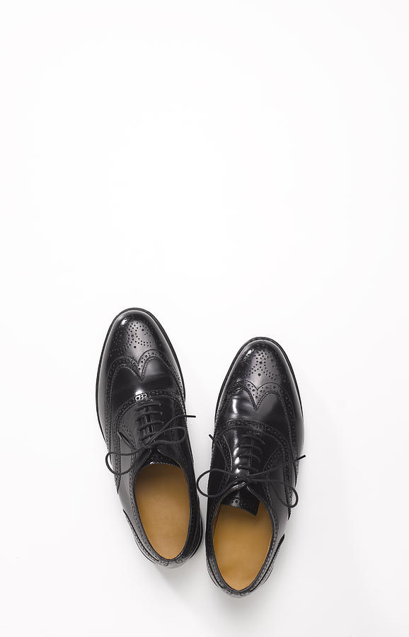 Pair of black brogue shoes with copy space Photograph by Peter Dazeley