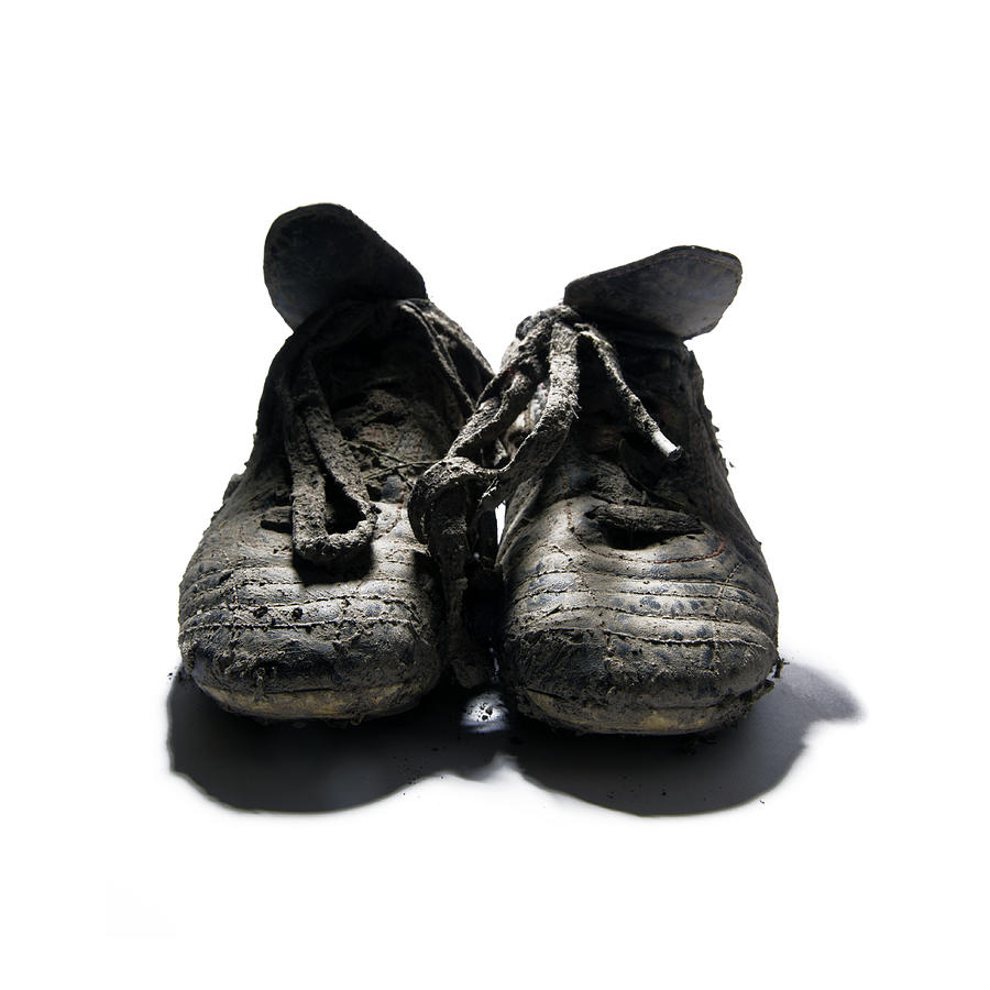 Pair of muddy boots on white background, close-up Photograph by Tom Chance