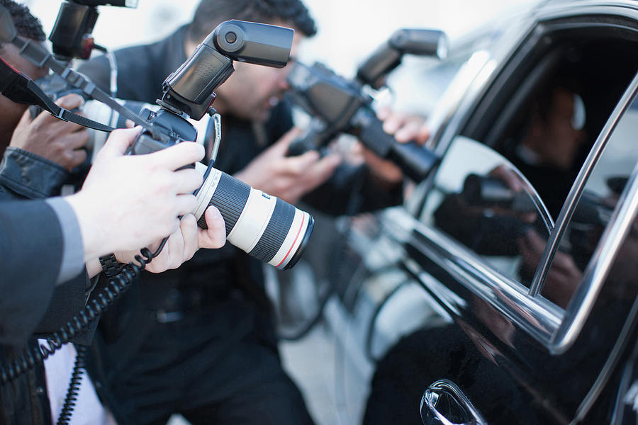 Paparazzi holding camera lens to car window Photograph by Paul Bradbury