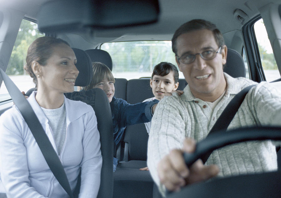 Parents with boy and girl in car wearing seatbelts, interior view Photograph by Laurence Mouton