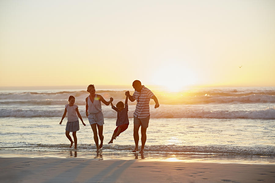 Parents with children enjoying vacation on beach Photograph by Morsa Images