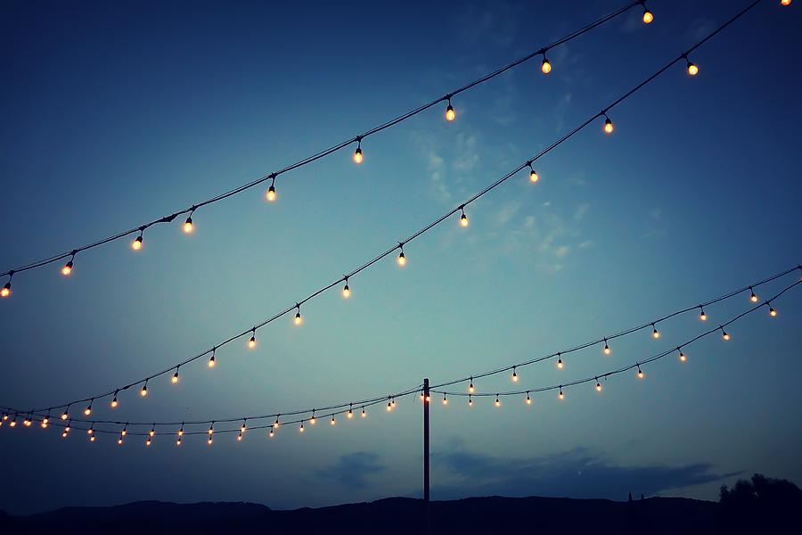 Party lights at outdoor wedding reception Photograph by Patricia Marroquin