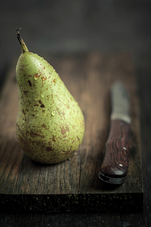 Pear With Water Trops And Knife On Photograph by Westend61