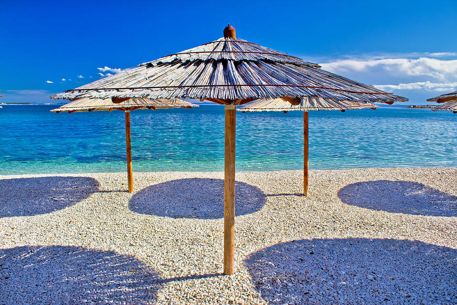 Pebble beach and turquoise sea umbrella Photograph by Brch Photography