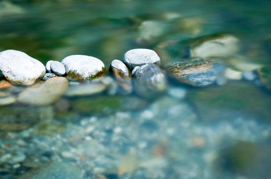 Pebbles and arranged stones in river water Photograph by Assalve
