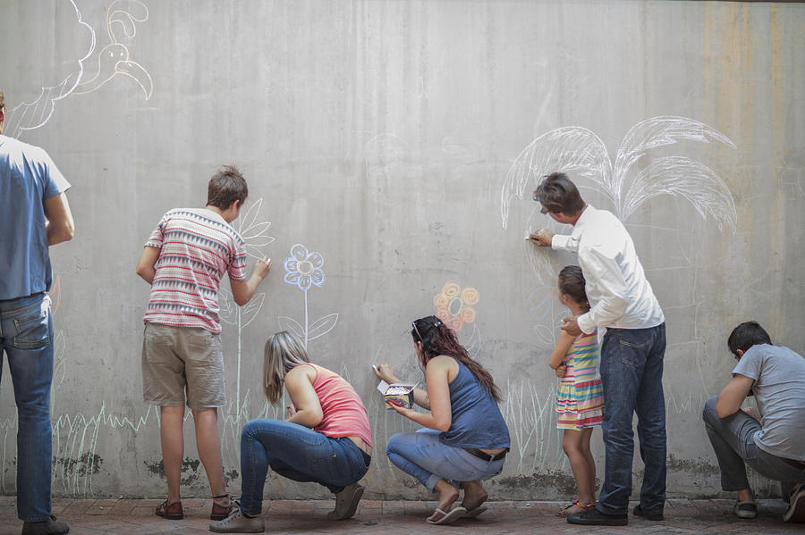 People drawing colourful pictures with chalk on a concrete wall Photograph by Westend61